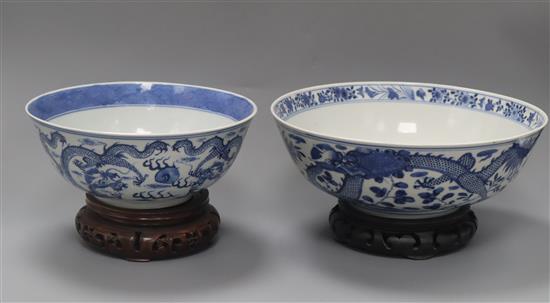 Two 19th century Chinese blue and white dragon bowls, Kangxi mark, on wooden stands diameter 25.5cm